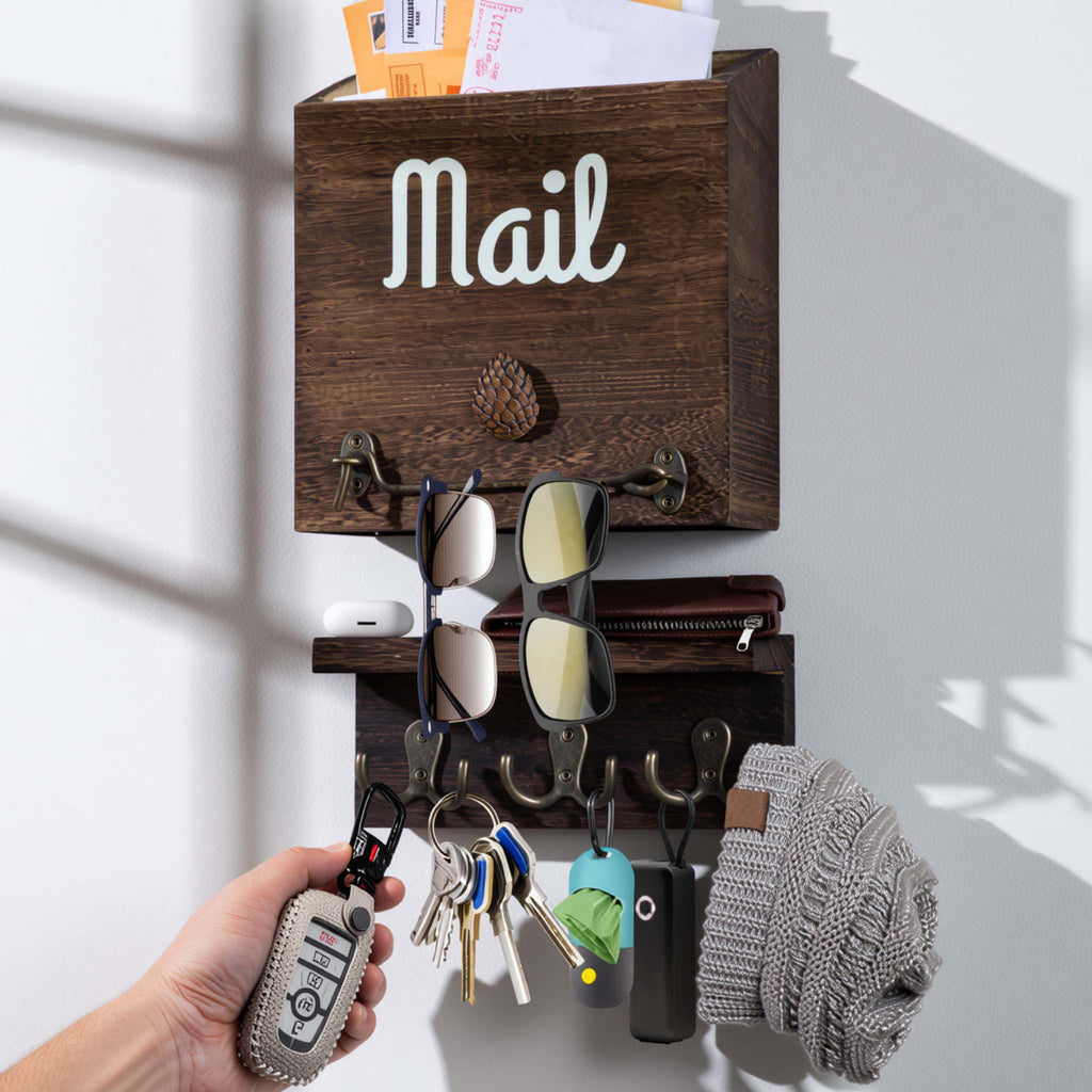 Wooden wall-mounted eBun mail organizer with keys, sunglasses, and a hat on a white background