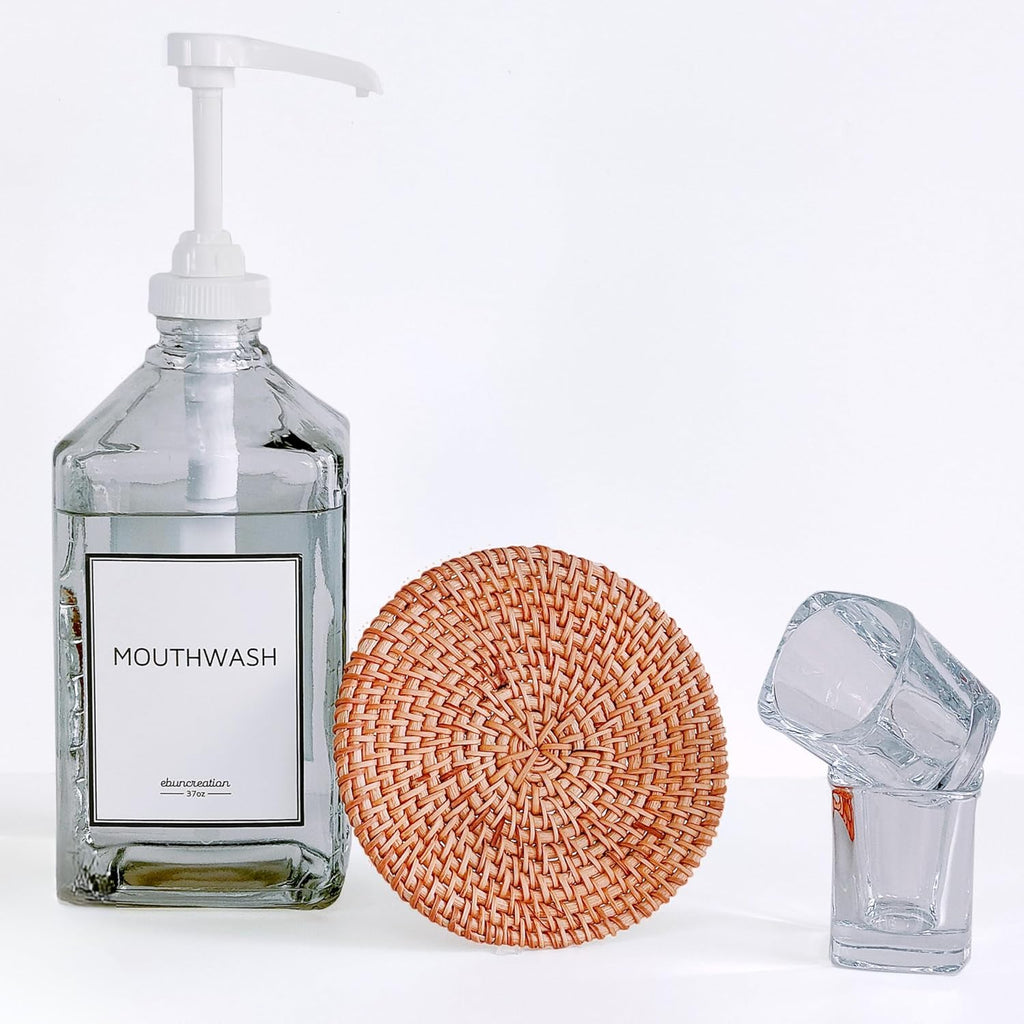 Mouthwash bottle with pump, woven coaster, and small glass container on a white background